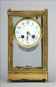 A late 19th century brass cased four glass clock The white enamel dial with Arabic numerals and