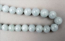 A jade bead necklace Each bead of pale green colour. 50 cms long. Overall good, some wear.