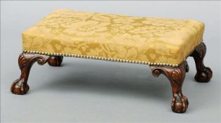 An 18th century style foot stool The overstuffed upholstered top supported on shell carved