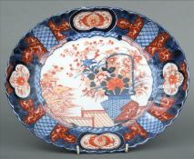 A 19th century Imari dish The scalloped shaped body decorated with flowering basket with buildings