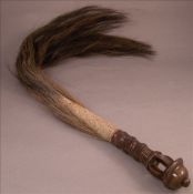 An animal`s tail fly whisk With carved and pierced wooden handle. 86 cms long overall. Generally