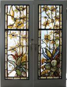 A pair of leaded stained glass panelled doors Each with scrolling foliate decoration, one with a