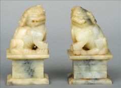 A pair of Chinese soapstone dogs-of-fo Each typically modelled, standing on a stepped plinth base.