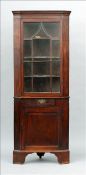 A George III mahogany standing corner cabinet The glazed top enclosing three serpentine shaped