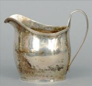 A George III silver cream jug, hallmarked London 1789, maker`s mark indistinct The front with