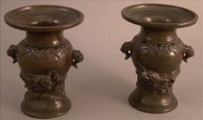 A pair of Japanese bronze vases Each modelled with a dragon riding stylised waves. 12.5 cms high. (