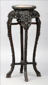 A late 19th century Chinese carved hardwood jardiniere stand The shaped marble inset top above the