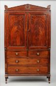 A 19th century mahogany linen press, in the manner of Thomas Hope The shaped architectural cornice