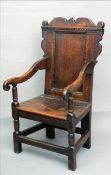 A 17th century Wainscot chair The shaped top rail above a panelled back issuing twin open arms above