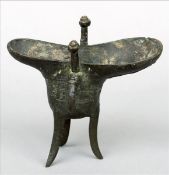 A Chinese archaistic bronze jue Of typical form, with moulded calligraphic text, geometric band