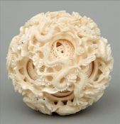 A large Chinese carved ivory puzzle ball The outer surface decorated with entwined dragons. 10 cms