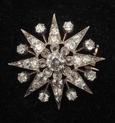 A Victorian unmarked gold diamond set star form brooch Formed as an eight point star, the central