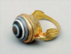 A Roman/Byzantine unmarked yellow metal glass bull`s eye set ring The central cabochon in a