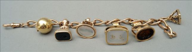 A quantity of 19th century unmarked gold fob seals Together on a 9 ct gold chain. 16 cms wide.