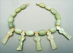 A Chinese carved jadeite necklace With reticulated beads interspersed with stylised figures. 40