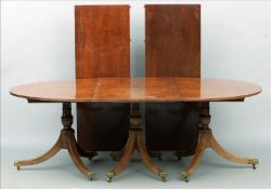 A George III and later "plum pudding" mahogany triple pedestal dining table Incorporating two