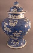 A Chinese porcelain blue and white baluster vase and cover Decorated overall with blossoming boughs.