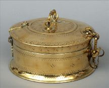 A 19th/20th century Indian polished brass tuck box Of circular section with swing handle, the body