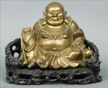 An Eastern bronze model of Buddha Modelled seated on a separate pierced and carved root wood base.