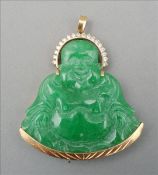 A gold and diamond mounted "jade" pendant Formed as Buddha with a ring of smaller diamonds around