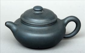 A Chinese pottery Yixing teapot and cover Of typical form, impressed seal mark to base and inside