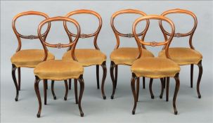 A set of six Victorian balloon back dining chairs The curved top rail above florally carved