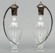 A pair of Art Nouveau style silver mounted clear glass claret jugs, each hallmarked for