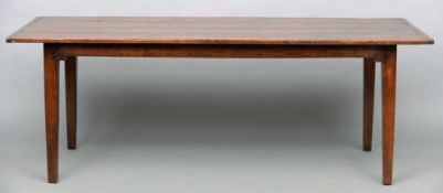 A 20th century farmhouse table The cleated four plank top above a shaped apron, standing on tapering