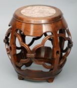 A Chinese carved hardwood stool Of pierced and carved barrel form with a marble inset top. 55 cms