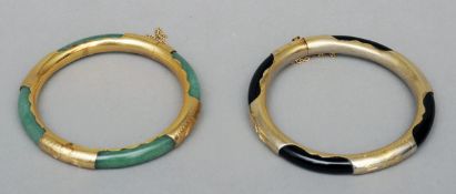 An unmarked yellow metal mounted jade bangle Together with a similar metal mounted hardstone bangle.