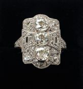 An Art Deco 18 ct gold and platinum diamond ring The pierced rectangular setting with three