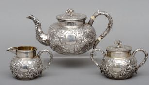 A 19th/20th century Chinese white metal three piece tea set, maker’s mark of CH and Chinese