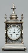 A 19th century silver plated mantel clock The finial mounted case with overall engraved scrolling