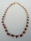An unmarked yellow metal and “amethyst” necklace Of graduated circular form. The largest