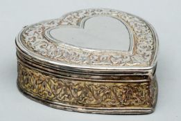 A Middle Eastern engraved white metal box Formed as a heart. 13 cms wide.