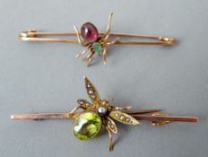 A 9 ct gold bar brooch Centrally set as a spider, the body mounted with an emerald and a cabochon