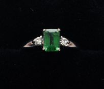 An 18 ct gold emerald and diamond ring The central emerald above pierced shoulders, each set with