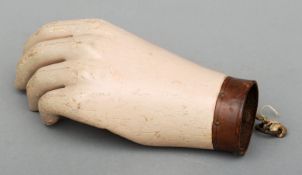 A French 19th century carved beechwood and painted hand The articulated thumb with drawstring, the