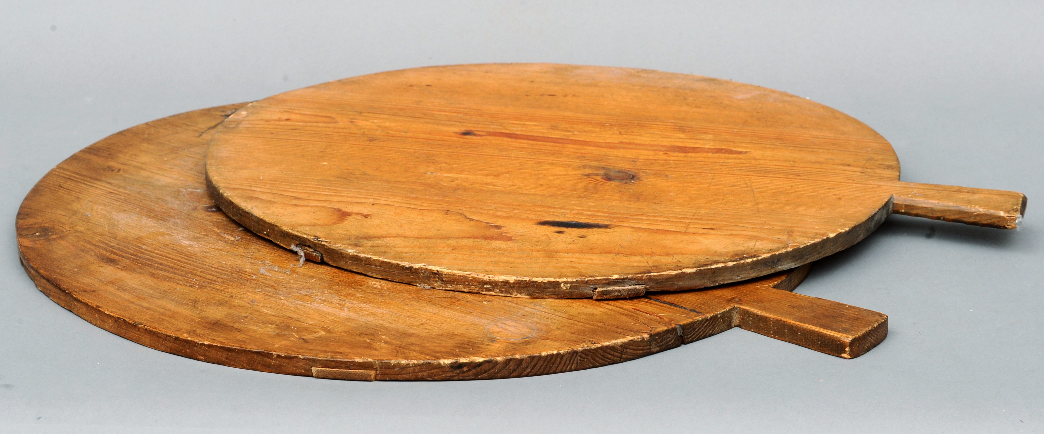 Two 19th century pine breadboards Of typical construction. The largest 55 cms diameter. (2)Generally