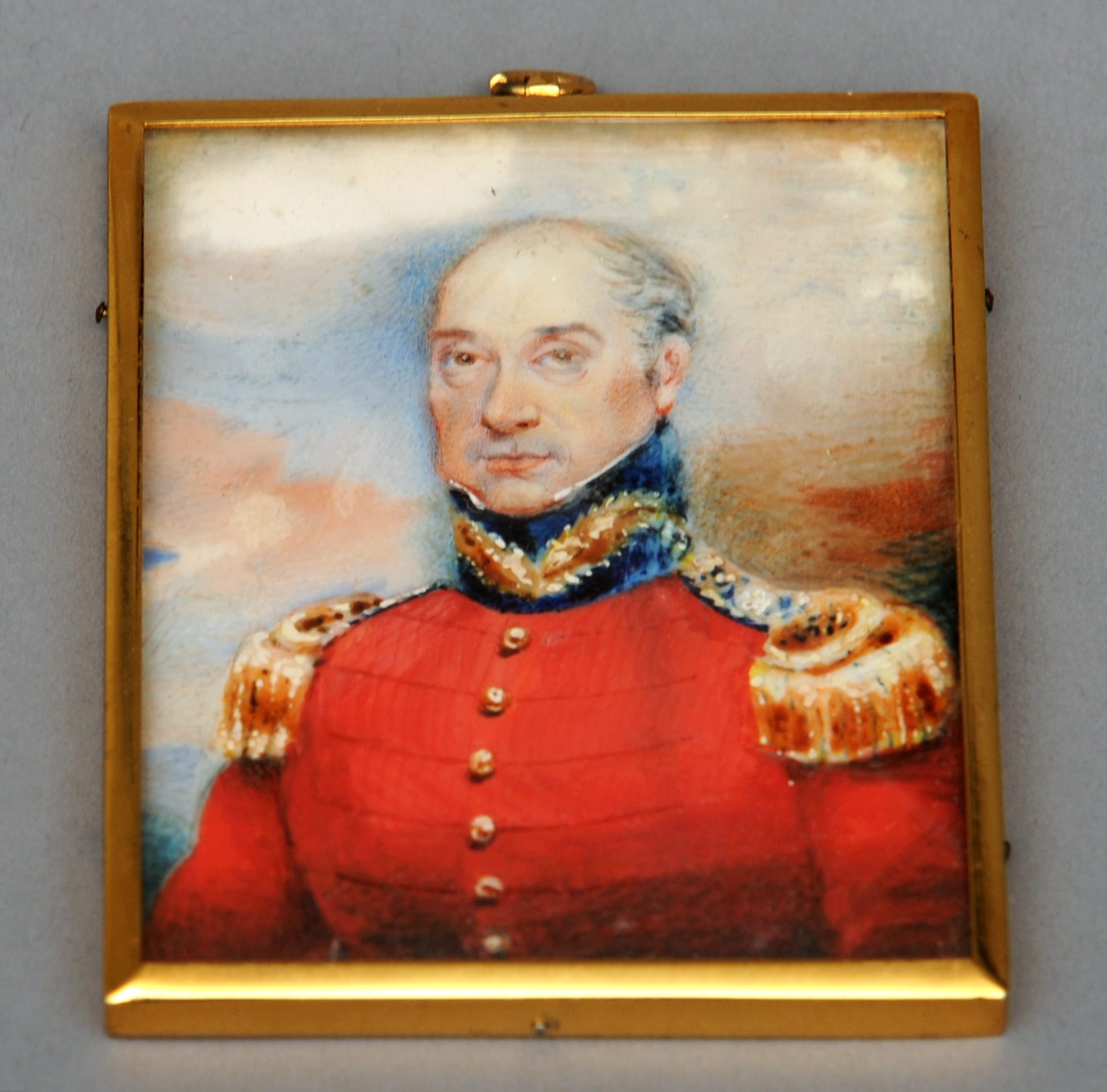 An English 19th century portrait miniature of an officer, in scarlet uniform with gold epaulettes On