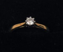 An 18 ct gold and platinum diamond solitaire ring The claw set diamond above pierced shoulders.