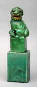 A Chinese green crackle glazed dog-of-fo Modelled in typical form, standing on a plinth base;