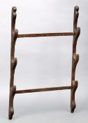 A 19th century oak hanging gun rack Of typical form. 80 cms high.Dirty and paint stained, some