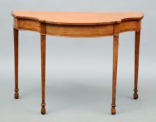 An Edwardian satinwood serpentine side table The shaped crossbanded top above an inset panelled