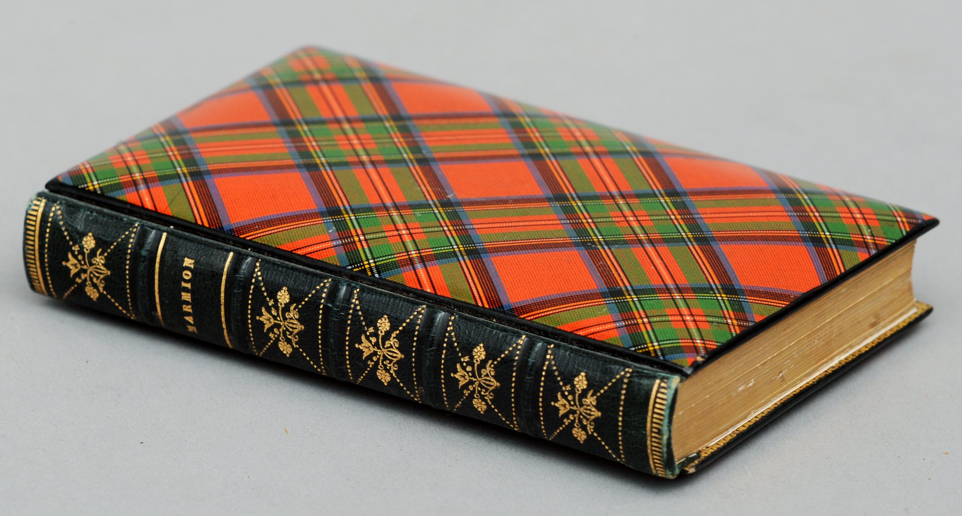 A 19th century tartan ware book cover In the Stuart tartan, the book Marmion by Sir Walter Scott,