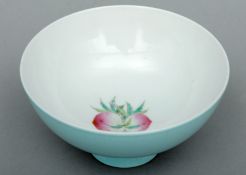 A Chinese porcelain bowl The interior centrally decorated with peaches, the exterior with a light