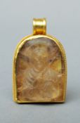 An antique carved rock crystal pendant With later high carat yellow metal mount and suspension
