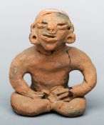 An early Chilean pottery figure The grotesque figure modelled seated with legs crossed. 14 cms