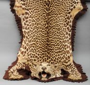 An early 20th century leopard skin rug, circa 1900 The head with inset glass eyes and open mouth,