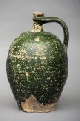 An 18th century Continental pottery ewer With strap handle integral to spout, allover green glaze.